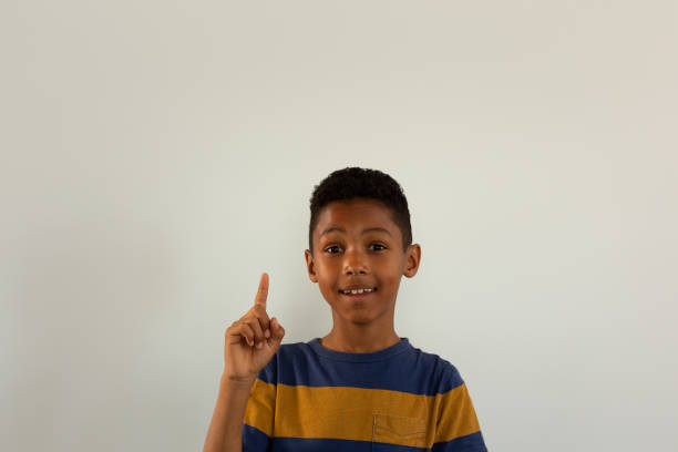 istock Happy boy looking at camera and pointing his finger up 1133783186