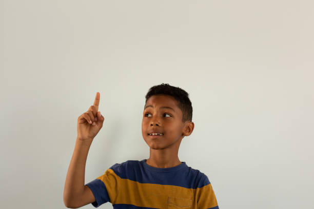 istock Thoughtful boy pointing his finger up while looking at his finger 1133783210