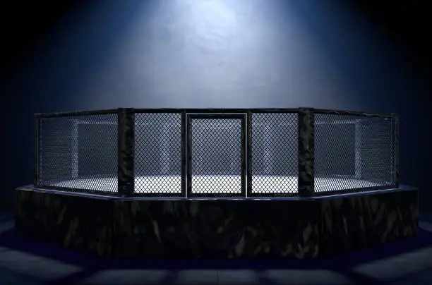 A 3D render of an MMA fight cage arena dressed in black padding spotlit by a single light on an isolated dark background - 3D render