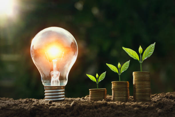 istock light bulb on soil with young plant growing on money stack. saving finance 1133783900