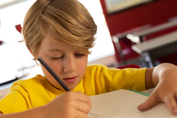 istock Boy drawing sketch on book at desk in a classroom 1133783953