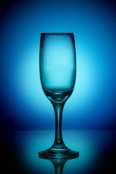 istock Empty wine glass on a blue background with a bright spot in the center 1133784112