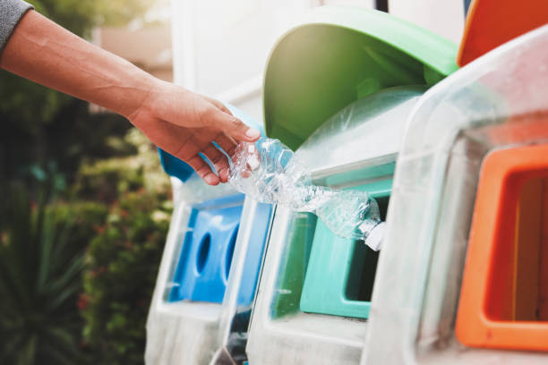 istock people putting plastic bottle in to recycle bin at park 1133784703