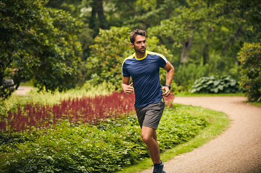Shot of a sporty middle-aged man out running in a park