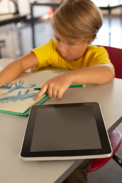 istock Boy drawing sketch on notebook at desk in a classroom 1133785573