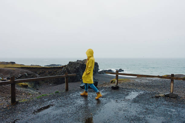 istock Young woman walking on the beach on a rainy day 1133785574