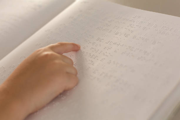 istock Blind boy hand reading a braille book in classroom 1133785895
