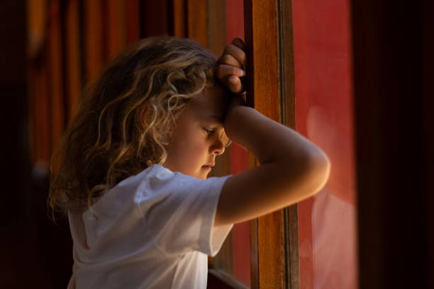 istock Sad schoolgirl leaning against a window at school 1133787320