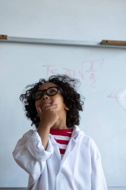 istock Thoughtful schoolboy with hand on chin standing in laboratory 1133789079