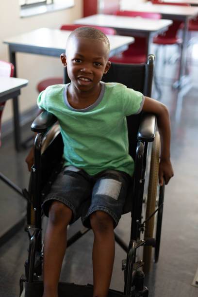 istock Disabled schoolboy looking at camera in a classroom 1133789930