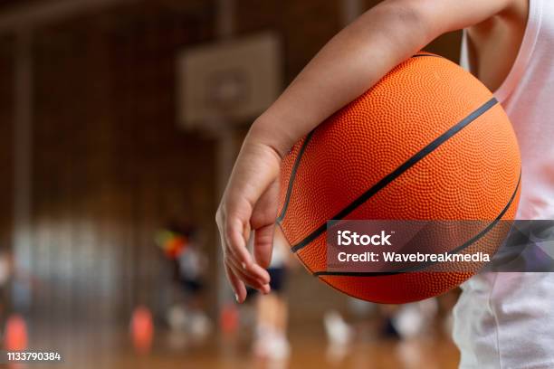 Schoolboy With Basketball Standing In Basketball Court Stock Photo - Download Image Now