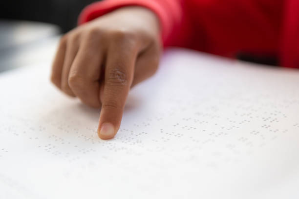 istock Blind schoolboy hand reading a braille book in classroom 1133793896