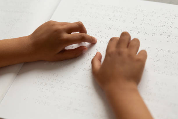 istock Blind schoolboy hands reading a braille book in classroom 1133794203