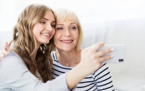 istock Charming blogger shooting selfie with mom on smartphone 1133797388