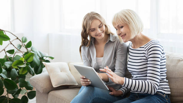 istock Daughter teaching senior mother to use tablet computer 1133797403