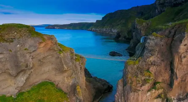 Aerial view of the rope bridge in Carrick-a-Rede in Northern Ireland two big cliffs with a bridge connecting them