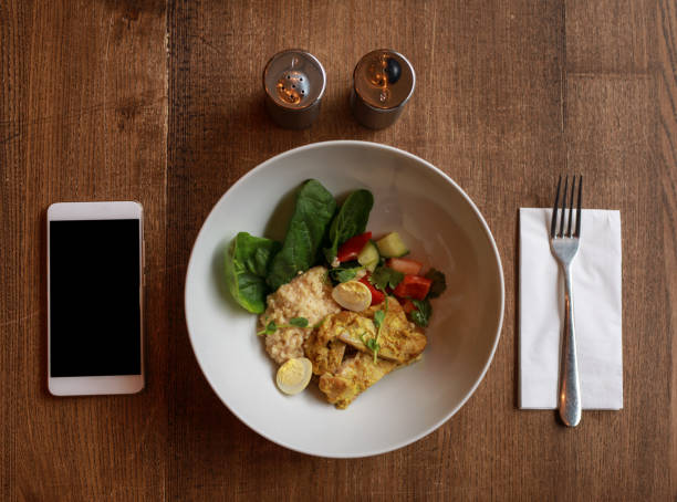 istock Plate with food and empty screen of smartphone on a table, flat lay 1133801142