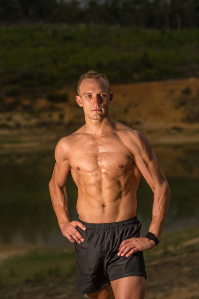 istock Shirtless male athlete resting after exercise outdoors hand on hip looking away 1133801327