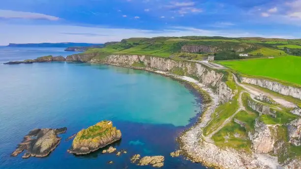 The view of the small islands on the sea in Carrick-a-Rede small islands formed on the sea fronting the big cliff of the mainland in North Ireland in Ireland