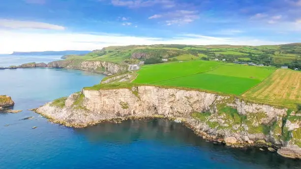 Aerial view of the cliff in Carrick-a-Rede Ireland where rock formatiuons are found on the ocean fronting the mainland in Ireland