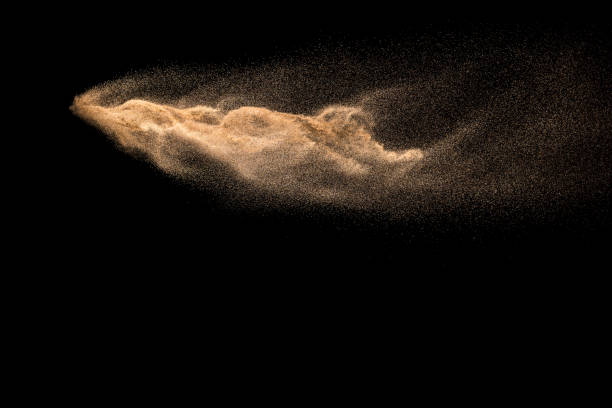 istock Golden sand explosion isolated on black background. Abstract sand cloud. Golden colored sand splash against dark background. Yellow sand fly wave in the air. 1133803180