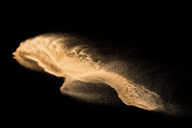 istock Golden sand explosion isolated on black background. Abstract sand cloud. Golden colored sand splash against dark background. Yellow sand fly wave in the air. 1133803215