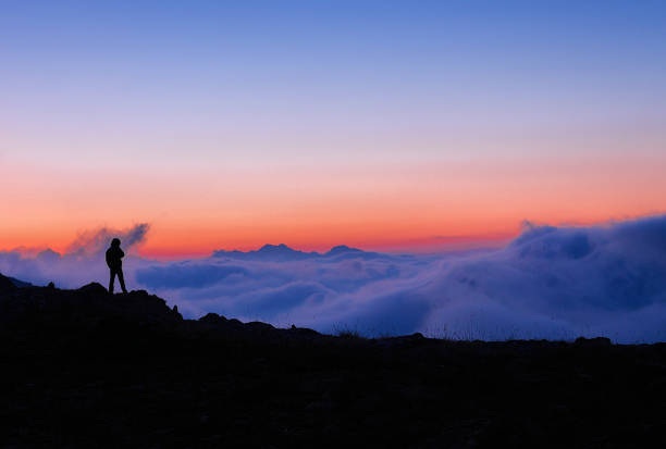 istock Silhouette of a man standing against the clouds at sunset 1133803968