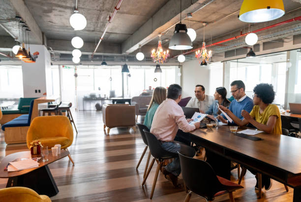 Multi ethnic group of professionals at a coworking office in a meeting discussing something