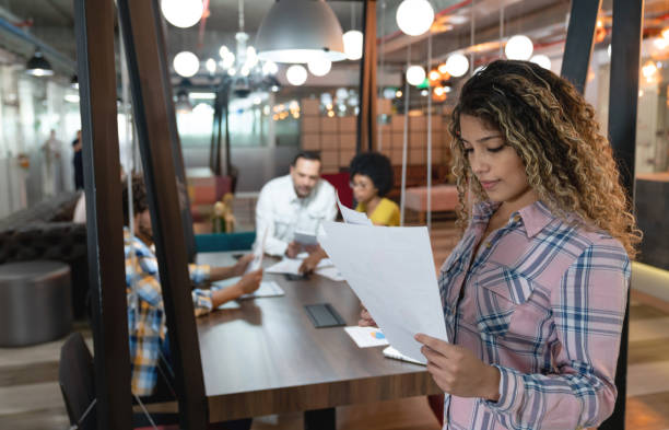 istock Young female professional at a coworking office looking at documents very focused 1133804315