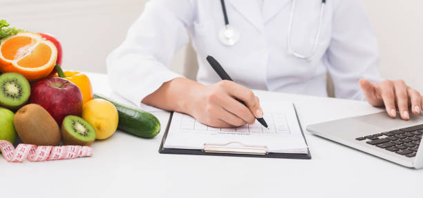 istock Doctor working with laptop and writing on paperwork 1133805265