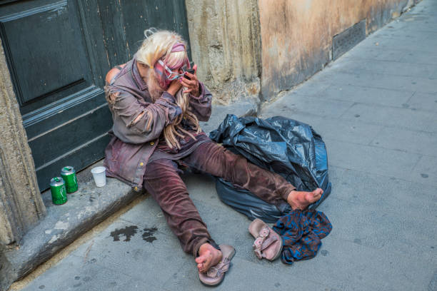 bezdomna kobieta pije piwo i stawia na makijaż. starsza biedna kobieta siedzi na podłodze. - ancient weapon audio zdjęcia i obrazy z banku zdjęć