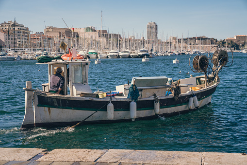 Typical wooden fishing boat sailing in the marina of Marseille Vieux Port