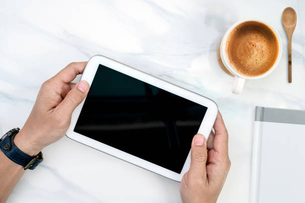 istock Shot of man hand holding white tablet with black screen on white table 1133811016