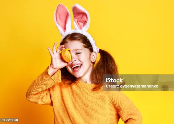 黄色のイースターエッグとバニー耳を持つおかしい幸せな子供の女の子 - イースターのストックフォトや画像を多数ご用意 - イースター, 子供, イースターエッグ
