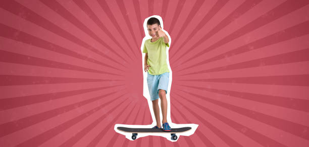 Portrait of a happy little boy is holding a skateboard in a skateboard park and looking at camera