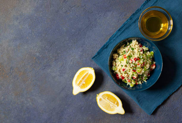 tabbouleh salat mit couscous, petersilie, zitrone, tomate, olivenöl. levantine vegetarischer salat. libanesische, arabische küche. dunkler hintergrund. top view. raum für text - tabbouleh vegeterian food middle stock-fotos und bilder