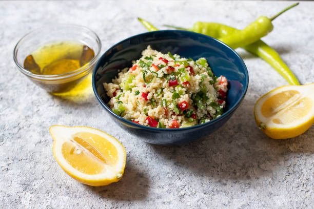 tabbouleh salat mit couscous, petersilie, zitrone, tomate, olivenöl. levantine vegetarischer salat. libanesische, arabische küche. leichter hintergrund. nahaufnahme - tabbouleh vegeterian food middle stock-fotos und bilder