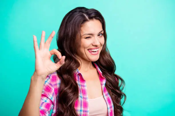 Close-up portrait of her she comic attractive cheerful optimistic wavy-haired lady wearing checked shirt showing ok-sign licking lip isolated over teal turquoise bright vivid shine background