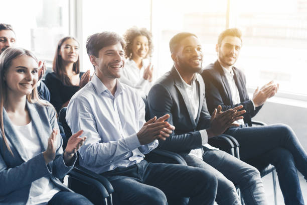 istock Happy diverse audience applauding at business seminar 1133819400
