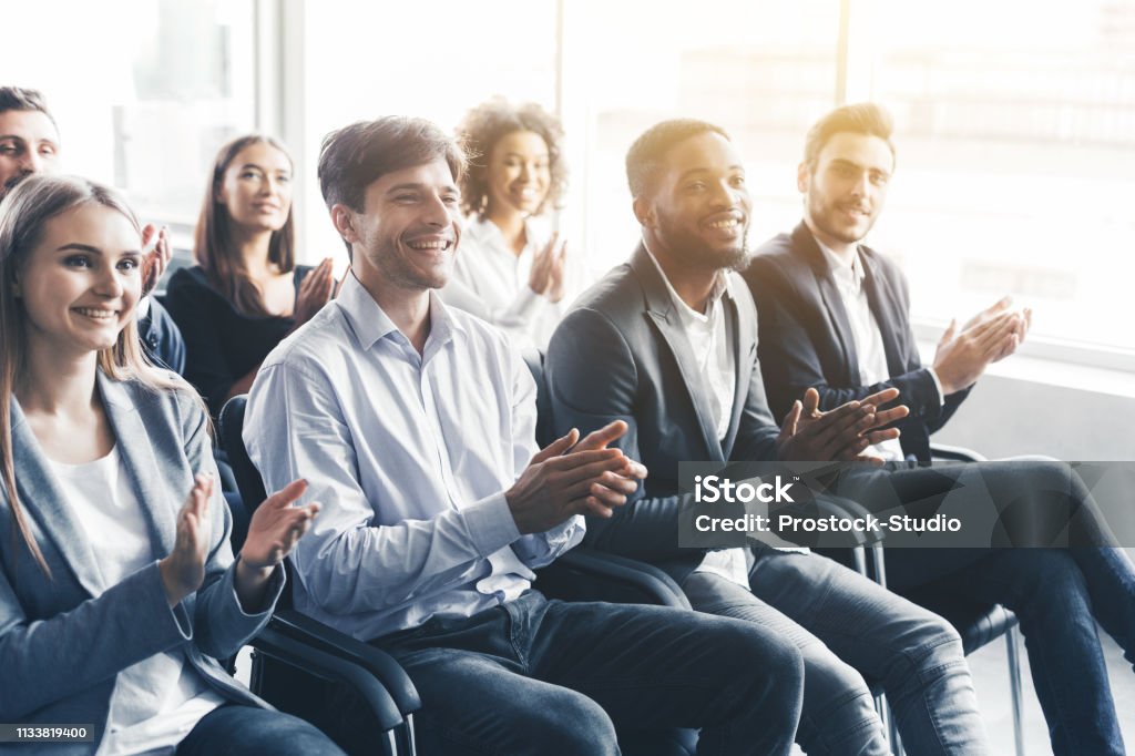 Happy diverse audience applauding at business seminar Happy diverse audience applauding at business seminar, in office Presentation - Speech Stock Photo