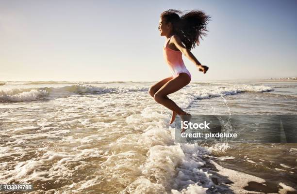 She Loves Jumping And Skipping Over All The Waves Stock Photo - Download Image Now - Child, Beach, Mid-Air