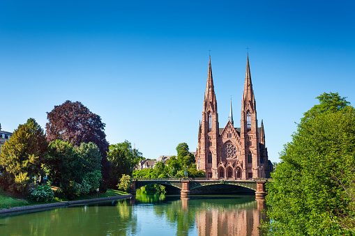 Panoramic view of the Ill river embankment with Saint Paul Church and Pont d'Auvergne in Strasbourg, France