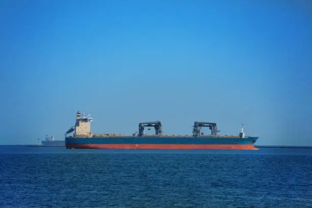 Photo of Dry cargo ship in the open sea against blue sky