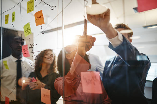 istock Businesspeople reading sticky notes during an office brainstorming session 1133823703