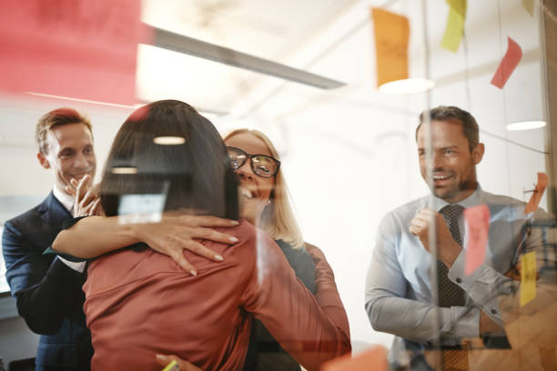 istock Two businesswomen hugging after an office brainstorming session 1133823737