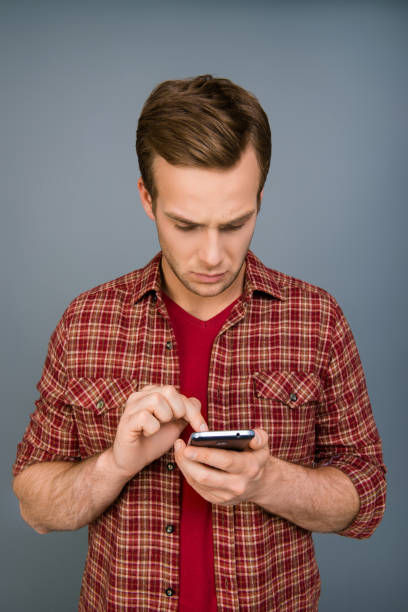 istock Minded serious young man typing message on smartphone 1133823750