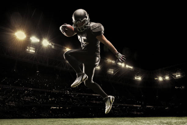 American football sportsman player on stadium running in action. Sport wallpaper with copyspace. Professional american football player on stadium running in action. Sport wallpaper with copyspace. 3D model of the stadium was created by me (the author) american football player stock pictures, royalty-free photos & images
