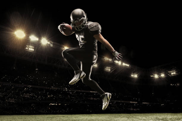 american football sportsman player on stadium running in action. sport wallpaper with copyspace. - sports uniform fotos imagens e fotografias de stock