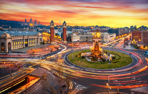 Long exposure photo of Fira de Barcelona, Plaça d'espanya (Spain square) and montjuic mountain in Barcelona at sunset with car light trails . Spain