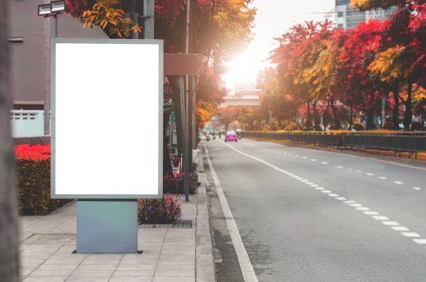 istock blank billboard white LED screen vertical outstanding in city on pathway side the road traffic for display advertisement text template promotion new branding at outdoor with colorful autumn leaves. 1133829198
